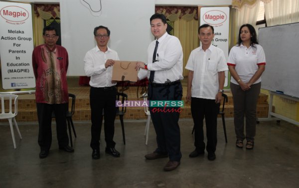 刘志良(左2起)代表赠送纪念品给莫哈末斯依丝祖基菲礼。右起为玛雅、麦志坚及莫哈末迪亚(左)。